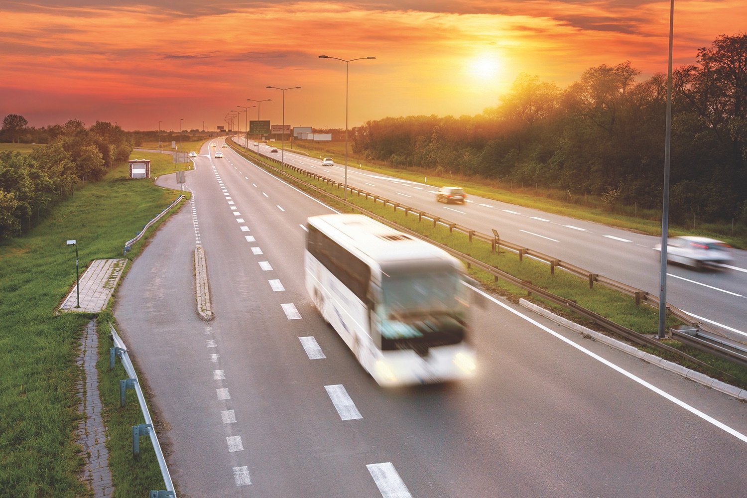 White bus in the rush hour on the highway at dusk